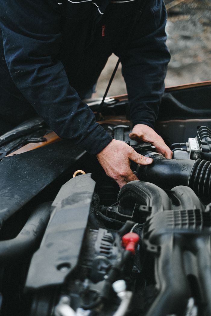 The Art of Drawing Readers In: Your attractive post title goes here Close-up of a mechanic's hands working on a car engine inside a workshop.